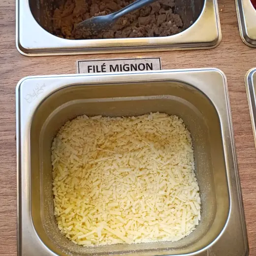 Parmesão na bancada de acompanhamentos da Massita