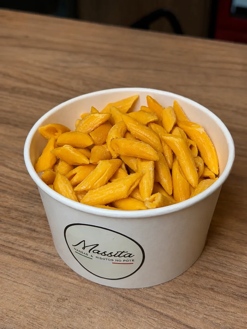 Pote de penne da Massita sobre mesa de madeira, em Gramado